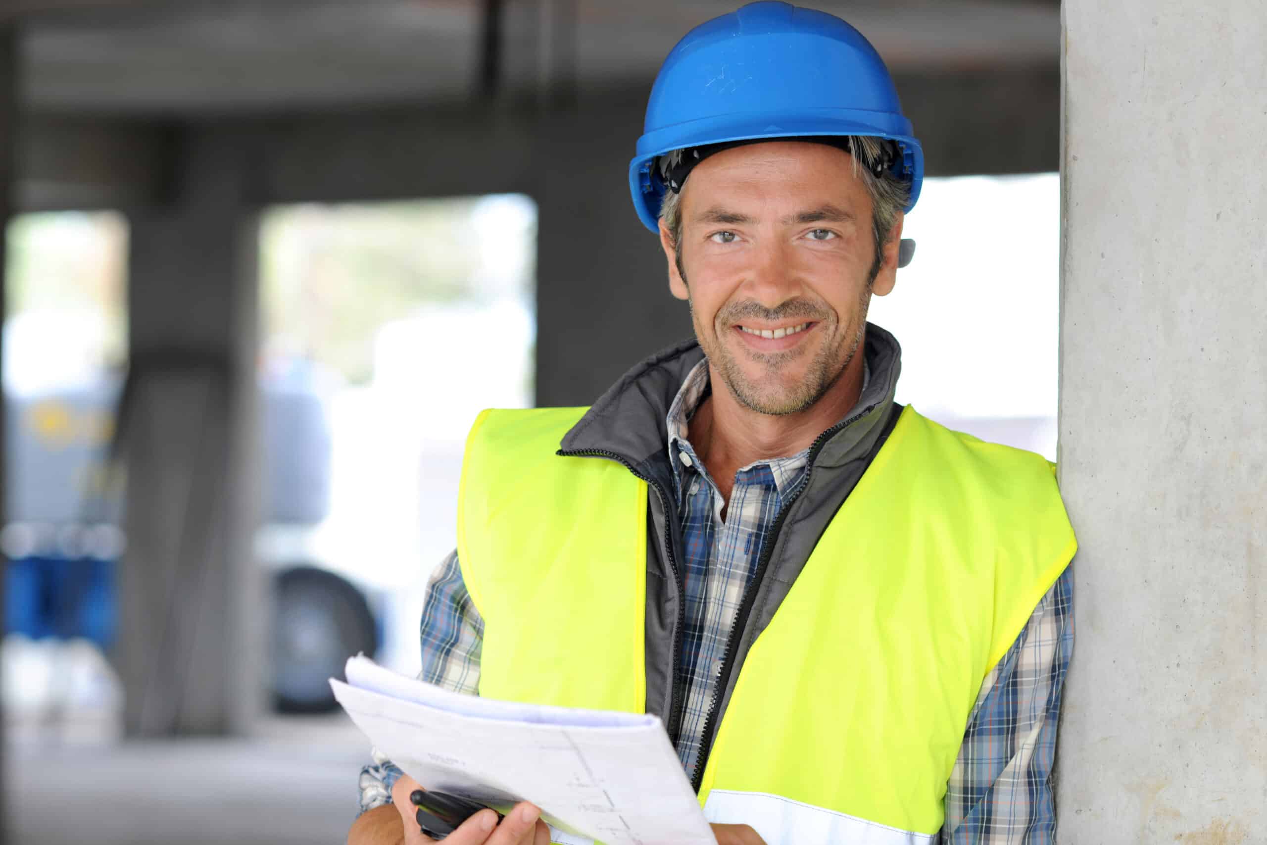 Smiling construction manager standing on building site